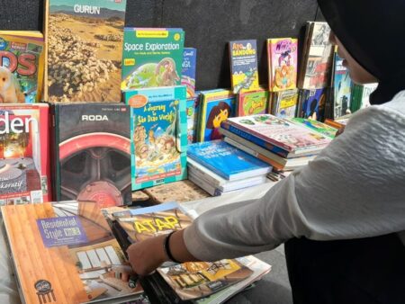 Seorang pembeli sedang melihat-lihat koleksi majalah di lapak Mahmud di kawasan Cikapundung.Foto Gilang Fathu Romadhan 