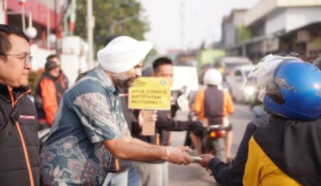 Site Manager Barry Callebaut, Simranjeet Singh bersama para peserta memberikan leaflet dan produk kepada para pengendara sepeda motor yang melintas di jalan Mohammad Toha, Kabupaten Bandung, Sabtu 3 Februari 2023.