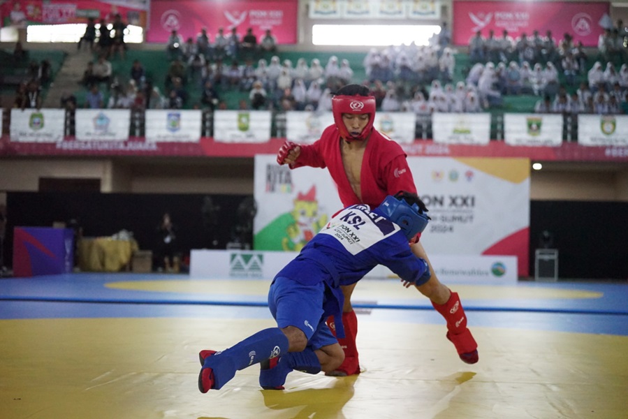 Atlit Sambo Jabar (merah) vs Atlit Sambo Kalsel (biru) kelas 71 kg, PON XXI Aceh – Sumut, pertandingan ini di menangkan Jabar, bertempat GOR Stabat Kab. Langkat, Rabu 180924/PB PON XXI SUMUT / Rahayu Effendi