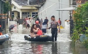 Tangkapan foto petugas gabungan menolong untuk mengevakuasi warga yang terkena banjir di Tanjung Senang, Bandar Lampung menggunakan perahu karet. (Sumber: Polda Lampung)