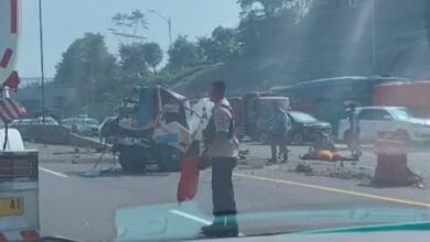 Korban tergeletak diantara mobil derek yang terlihat rusak berat.