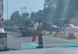 Korban tergeletak diantara mobil derek yang terlihat rusak berat.