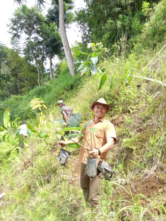 Kepala Desa Kertawangi,  Yanto Bin Surya alias Steve Ewon saat menanam pohon di Kampung Kebon Cau, Selasa, 30/12/2025.