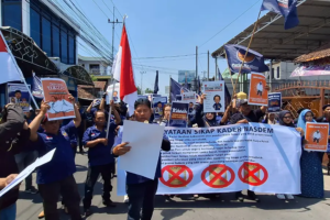 Aksi massa Aliansi Kader NasDem Mojokerto membawa spanduk dukungan untuk Surya Paloh dan menuntut permintaan maaf dari Majalah Tempo.