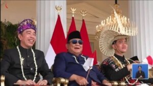 Prabowo Subianto diapit Jokowi dan Gibran setelah upacara. 7